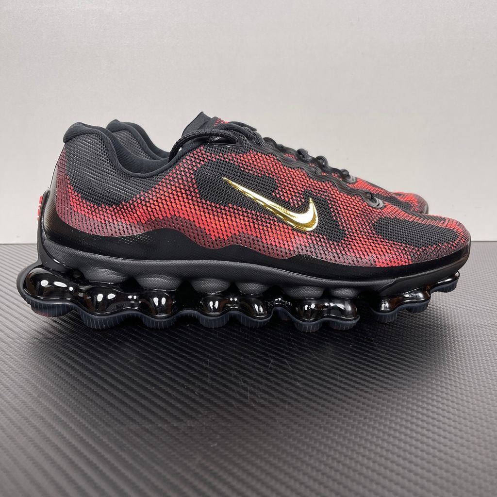 Side profile of the Nike Air Liquid Max sneaker in the 'Bright Crimson Fire Red' colorway, showcasing a fluid, aerodynamic mesh upper with vibrant red and crimson synthetic overlays, and a prominent visible Max Air cushioning unit in the heel and midfoot.