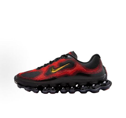 Side profile of the Nike Air Liquid Max sneaker in the 'Bright Crimson Fire Red' colorway, showcasing a fluid, aerodynamic mesh upper with vibrant red and crimson synthetic overlays, and a prominent visible Max Air cushioning unit in the heel and midfoot.