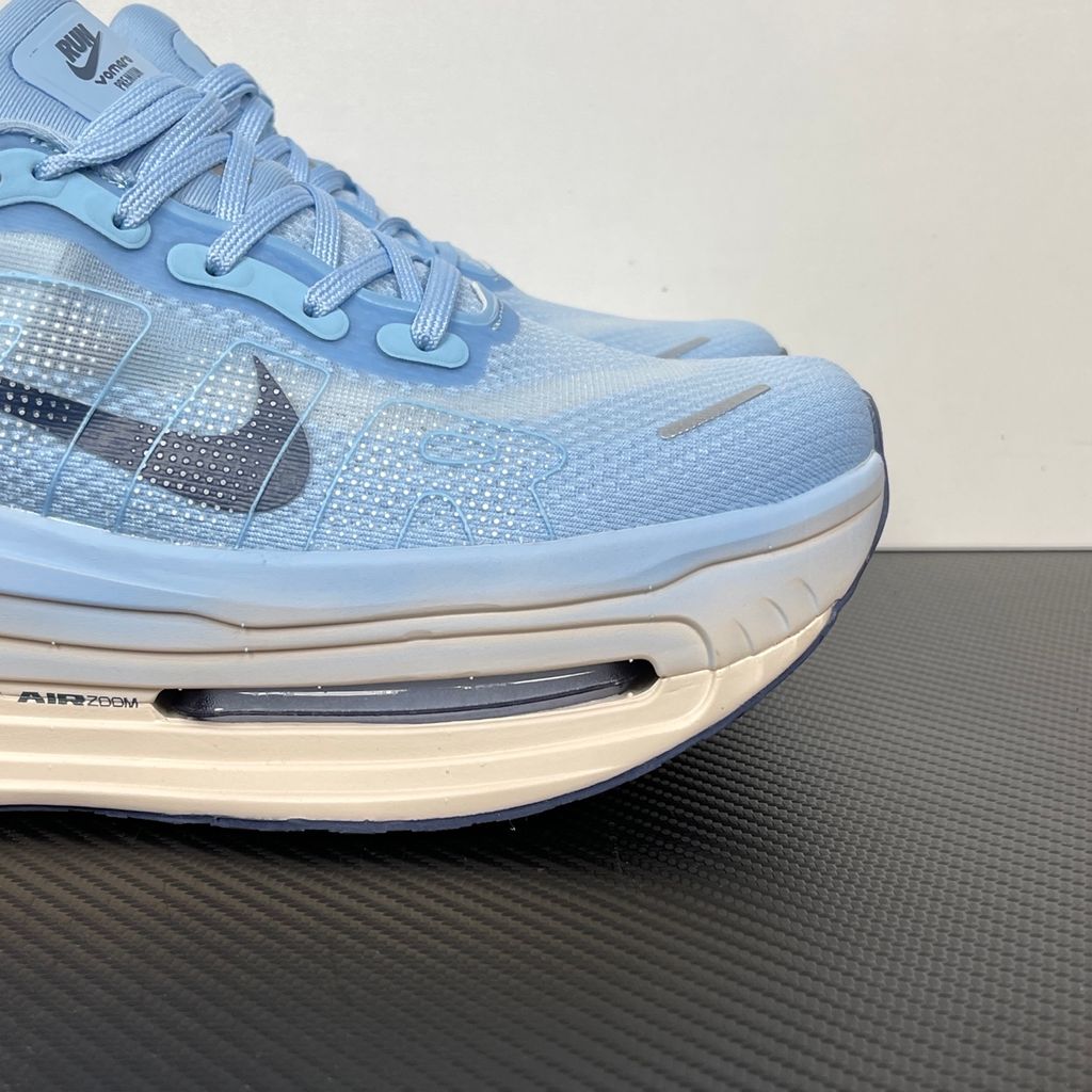 Side profile of the Nike Vomero Premium sneaker in the 'Aluminum' colorway, showcasing the heavily layered breathable mesh upper, cool-toned metallic synthetic overlays, the iconic plastic midfoot cage, and the sculpted Cushlon midsole.