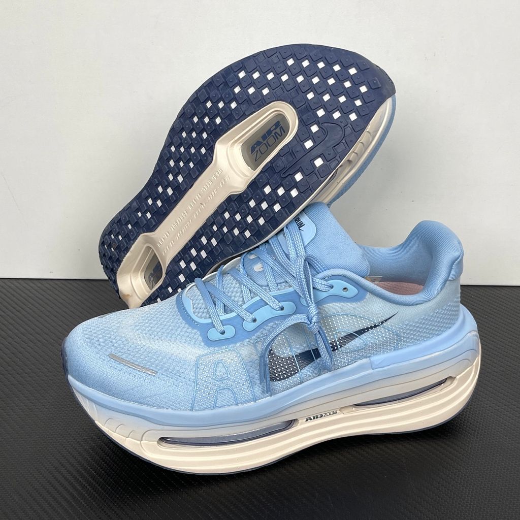 Side profile of the Nike Vomero Premium sneaker in the 'Aluminum' colorway, showcasing the heavily layered breathable mesh upper, cool-toned metallic synthetic overlays, the iconic plastic midfoot cage, and the sculpted Cushlon midsole.