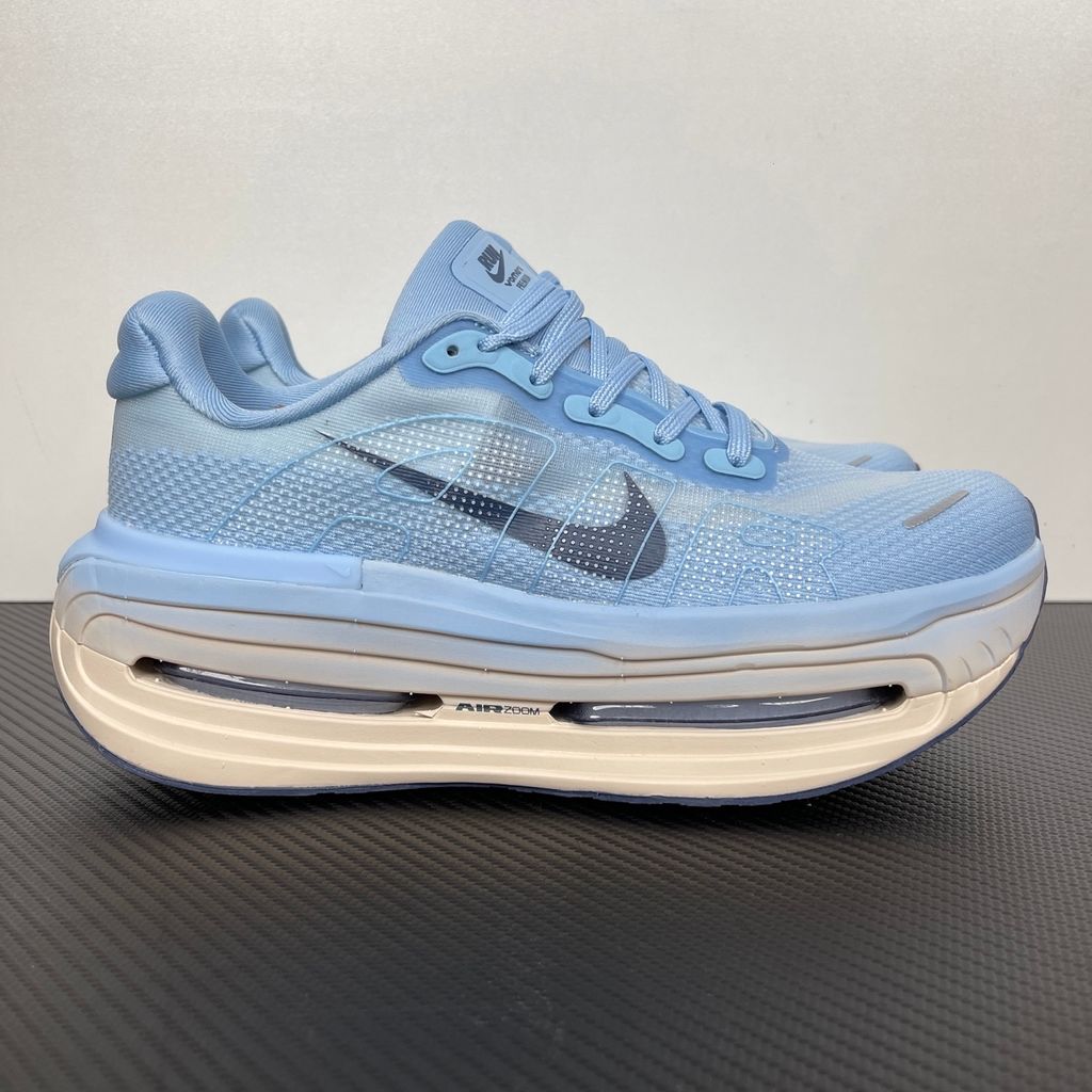Side profile of the Nike Vomero Premium sneaker in the 'Aluminum' colorway, showcasing the heavily layered breathable mesh upper, cool-toned metallic synthetic overlays, the iconic plastic midfoot cage, and the sculpted Cushlon midsole.