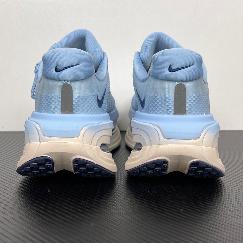 Side profile of the Nike Vomero Premium sneaker in the 'Aluminum' colorway, showcasing the heavily layered breathable mesh upper, cool-toned metallic synthetic overlays, the iconic plastic midfoot cage, and the sculpted Cushlon midsole.