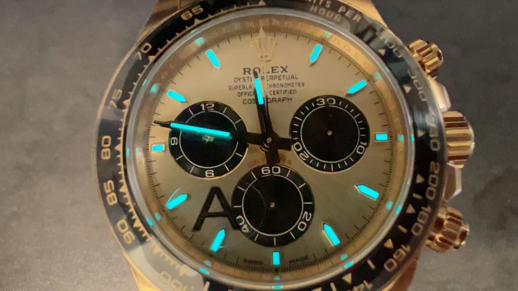 Front-facing view of the Rolex Cosmograph Daytona 126518LN, highlighting the polished 18ct yellow gold case, contrasting black Cerachrom tachymetric bezel, and the sophisticated golden and black dial with snailed counters.