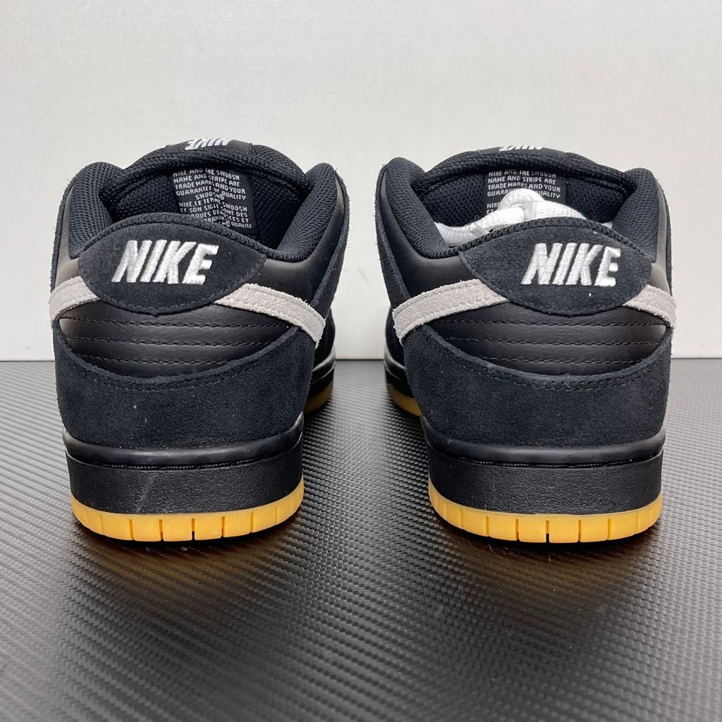 Side profile of the Nike Dunk Low Pro SB 'Black White Gum' sneaker, showcasing the clean black and white leather color blocking, signature padded SB tongue, and the classic gum rubber outsole.