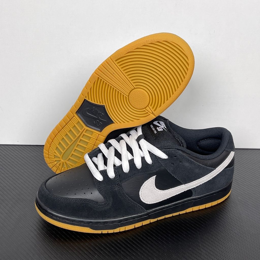 Side profile of the Nike Dunk Low Pro SB 'Black White Gum' sneaker, showcasing the clean black and white leather color blocking, signature padded SB tongue, and the classic gum rubber outsole.