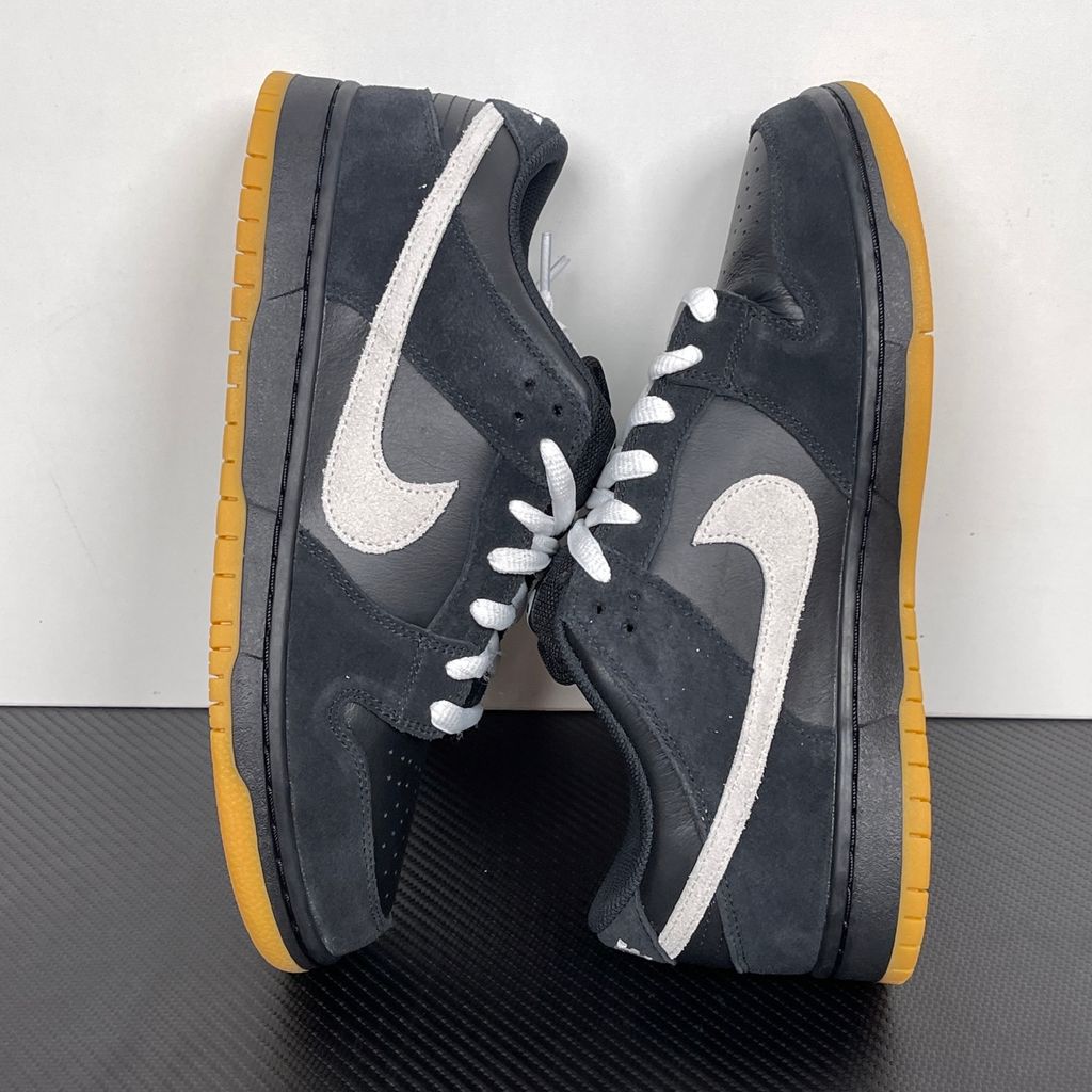 Side profile of the Nike Dunk Low Pro SB 'Black White Gum' sneaker, showcasing the clean black and white leather color blocking, signature padded SB tongue, and the classic gum rubber outsole.