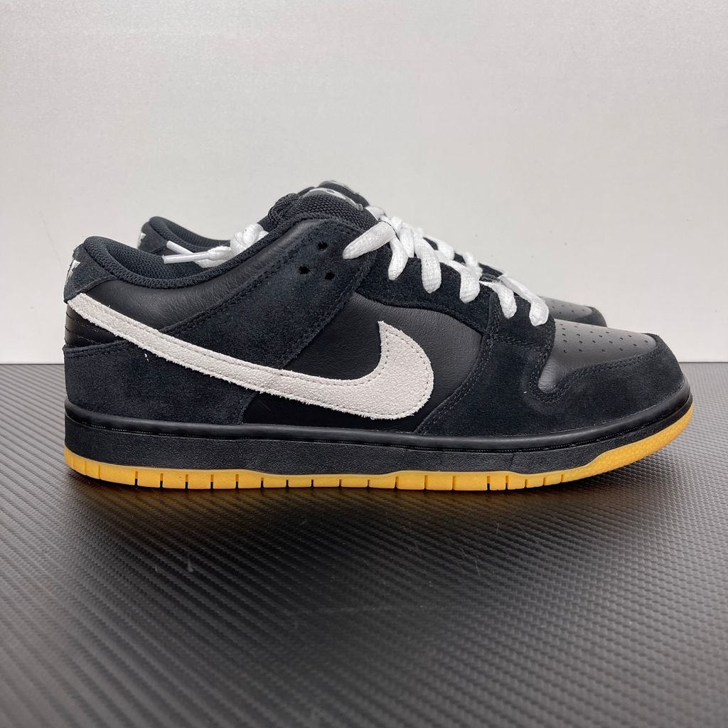 Side profile of the Nike Dunk Low Pro SB 'Black White Gum' sneaker, showcasing the clean black and white leather color blocking, signature padded SB tongue, and the classic gum rubber outsole.
