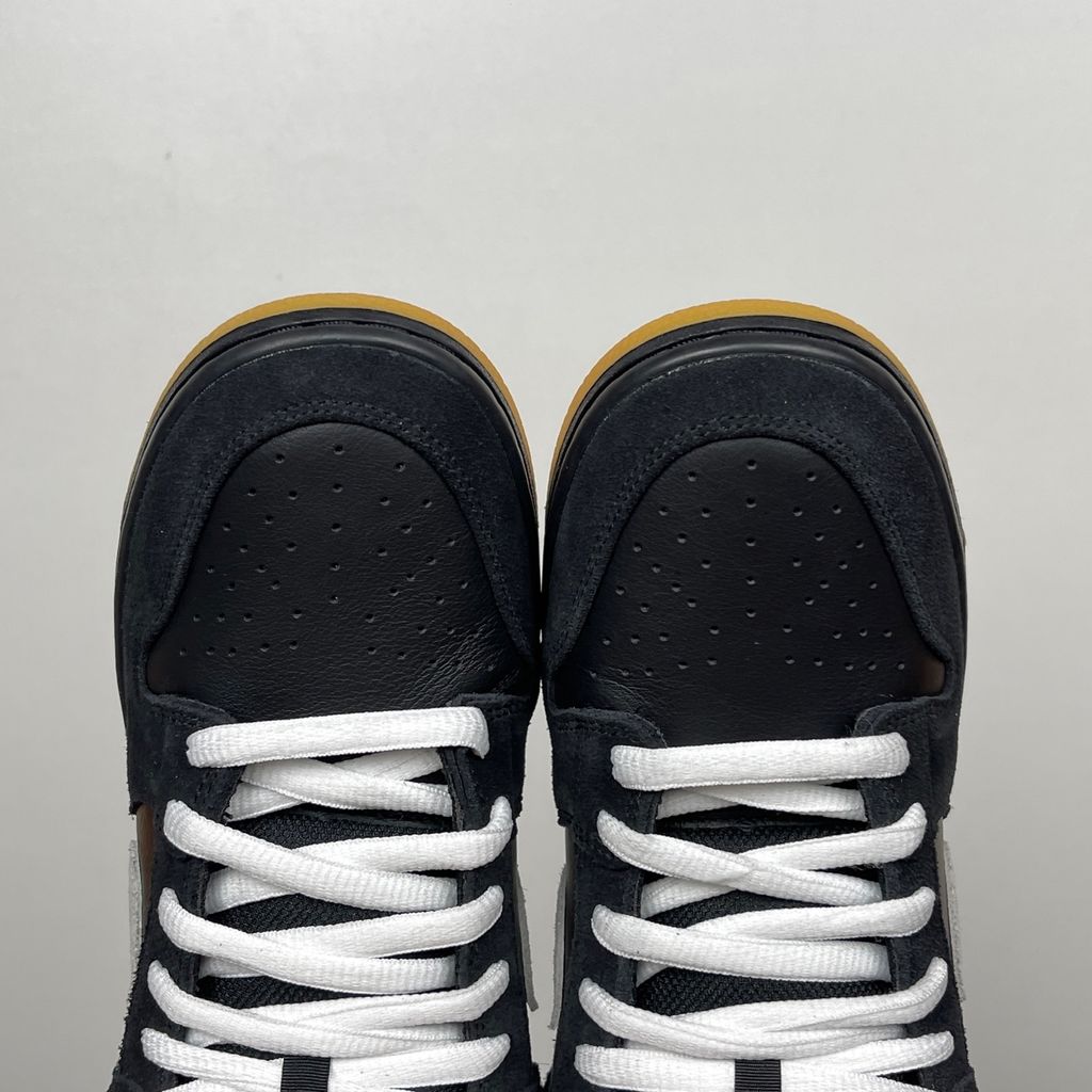 Side profile of the Nike Dunk Low Pro SB 'Black White Gum' sneaker, showcasing the clean black and white leather color blocking, signature padded SB tongue, and the classic gum rubber outsole.