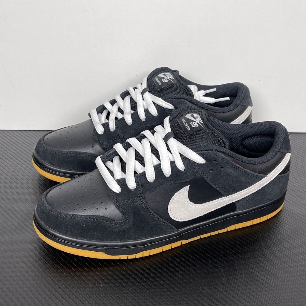 Side profile of the Nike Dunk Low Pro SB 'Black White Gum' sneaker, showcasing the clean black and white leather color blocking, signature padded SB tongue, and the classic gum rubber outsole.