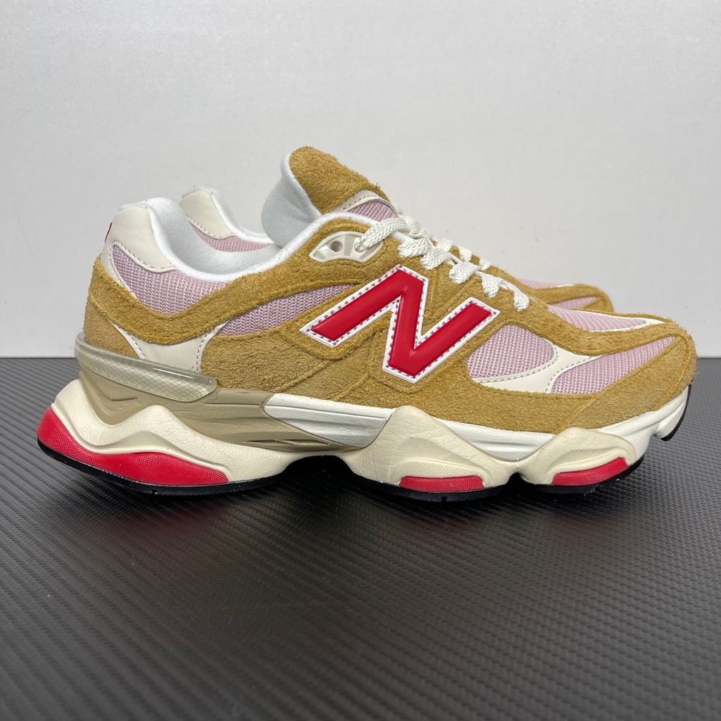 Side profile of the New Balance 9060 sneaker in the striking 'Great Plains True Red' colorway, showcasing the retro-futuristic chunky midsole, highly textured breathable mesh upper with vibrant red suede overlays, and the signature metallic 'N' logo.