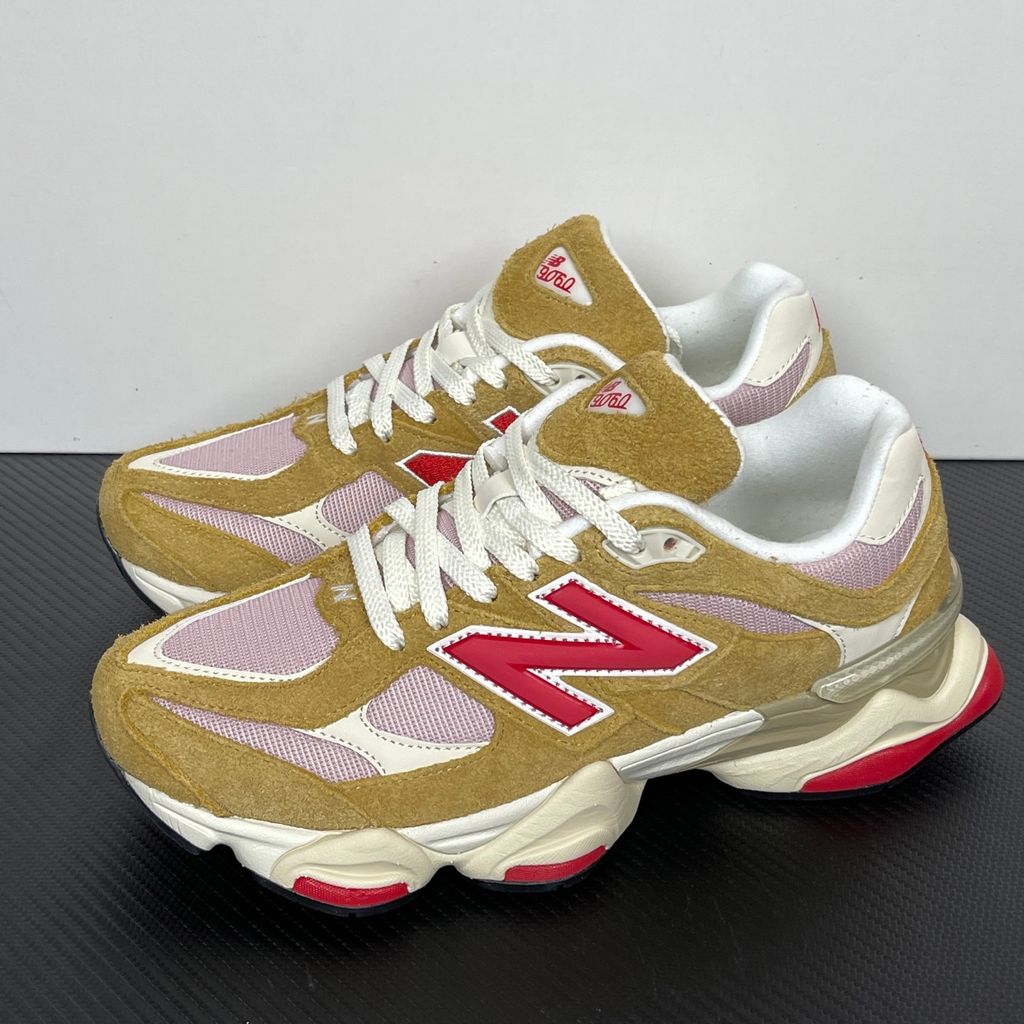 Side profile of the New Balance 9060 sneaker in the striking 'Great Plains True Red' colorway, showcasing the retro-futuristic chunky midsole, highly textured breathable mesh upper with vibrant red suede overlays, and the signature metallic 'N' logo.