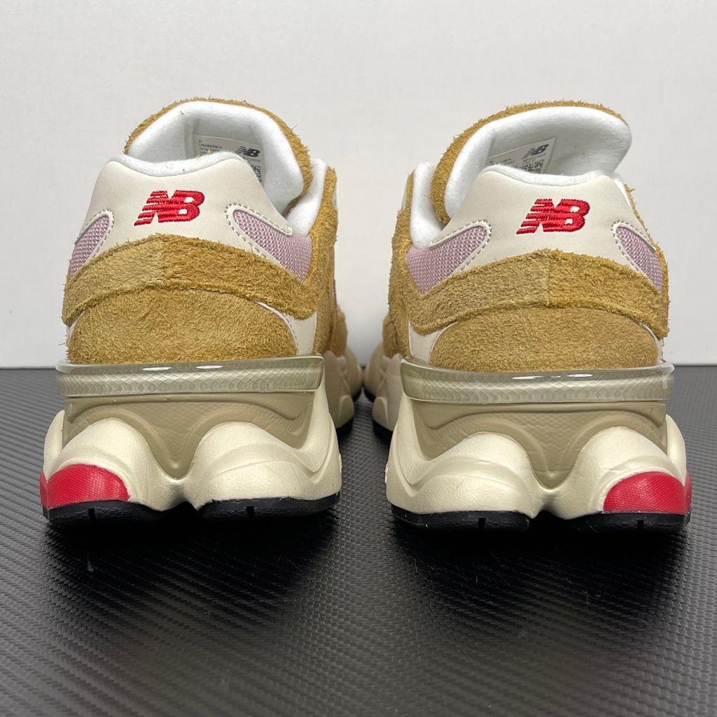 Side profile of the New Balance 9060 sneaker in the striking 'Great Plains True Red' colorway, showcasing the retro-futuristic chunky midsole, highly textured breathable mesh upper with vibrant red suede overlays, and the signature metallic 'N' logo.