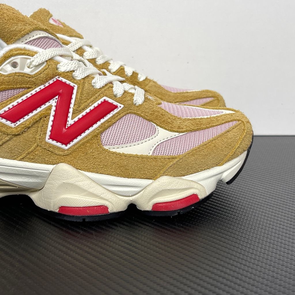 Side profile of the New Balance 9060 sneaker in the striking 'Great Plains True Red' colorway, showcasing the retro-futuristic chunky midsole, highly textured breathable mesh upper with vibrant red suede overlays, and the signature metallic 'N' logo.