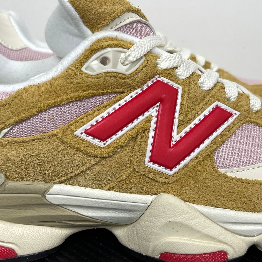 Side profile of the New Balance 9060 sneaker in the striking 'Great Plains True Red' colorway, showcasing the retro-futuristic chunky midsole, highly textured breathable mesh upper with vibrant red suede overlays, and the signature metallic 'N' logo.