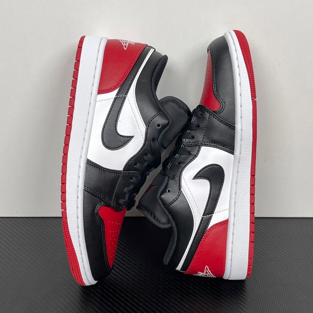Side profile of the Air Jordan 1 Low 'Bred Toe 2.0' sneaker, showcasing the sharp white, black, and red color blocking, signature Swoosh branding, and the classic low-top profile.