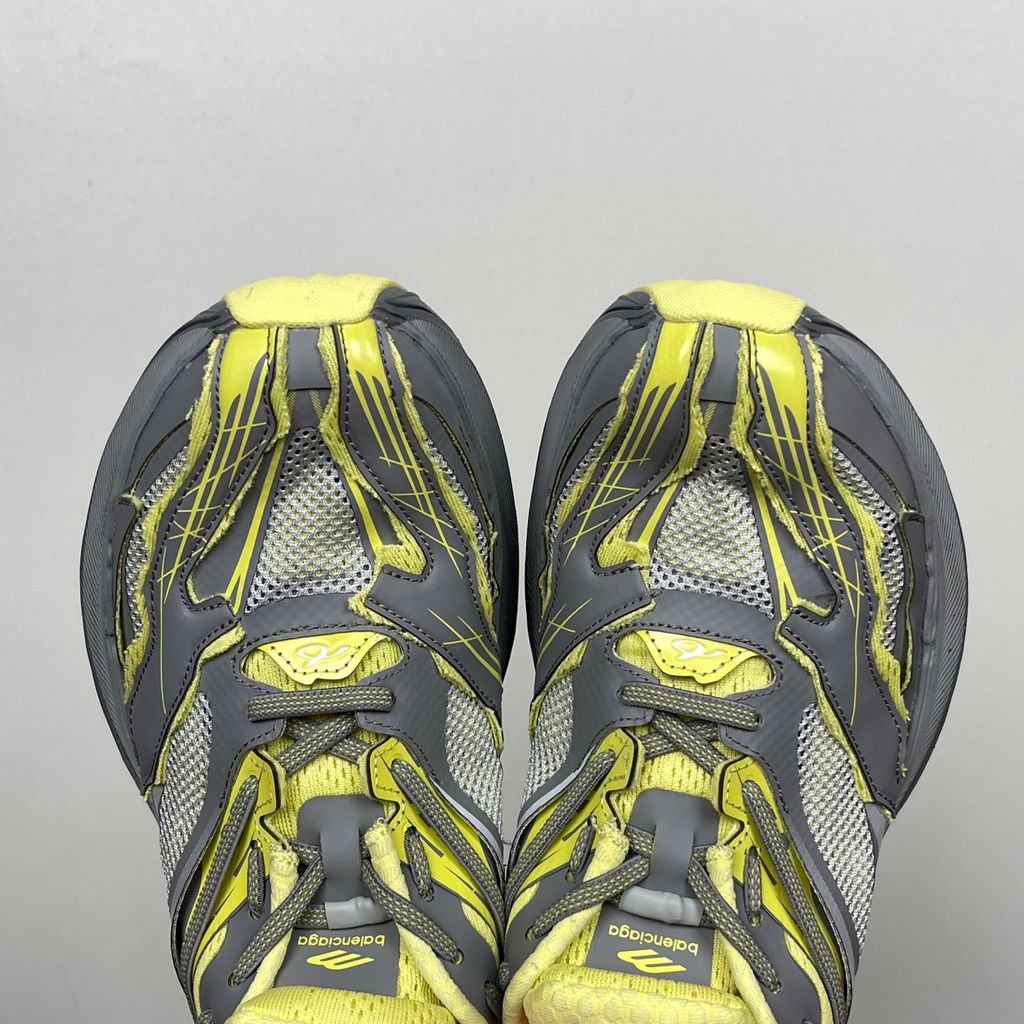 Side profile of the Balenciaga Jet sneaker, highlighting the dynamic grey and light yellow colorway, intricate embossed and printed detailing, and the dramatic 4.25cm thick sculpted sole unit.