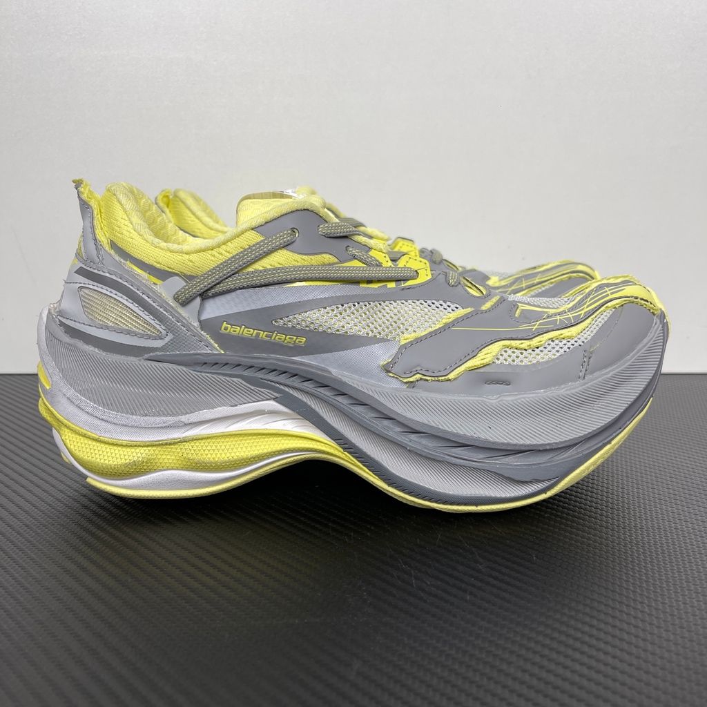 Side profile of the Balenciaga Jet sneaker, highlighting the dynamic grey and light yellow colorway, intricate embossed and printed detailing, and the dramatic 4.25cm thick sculpted sole unit.