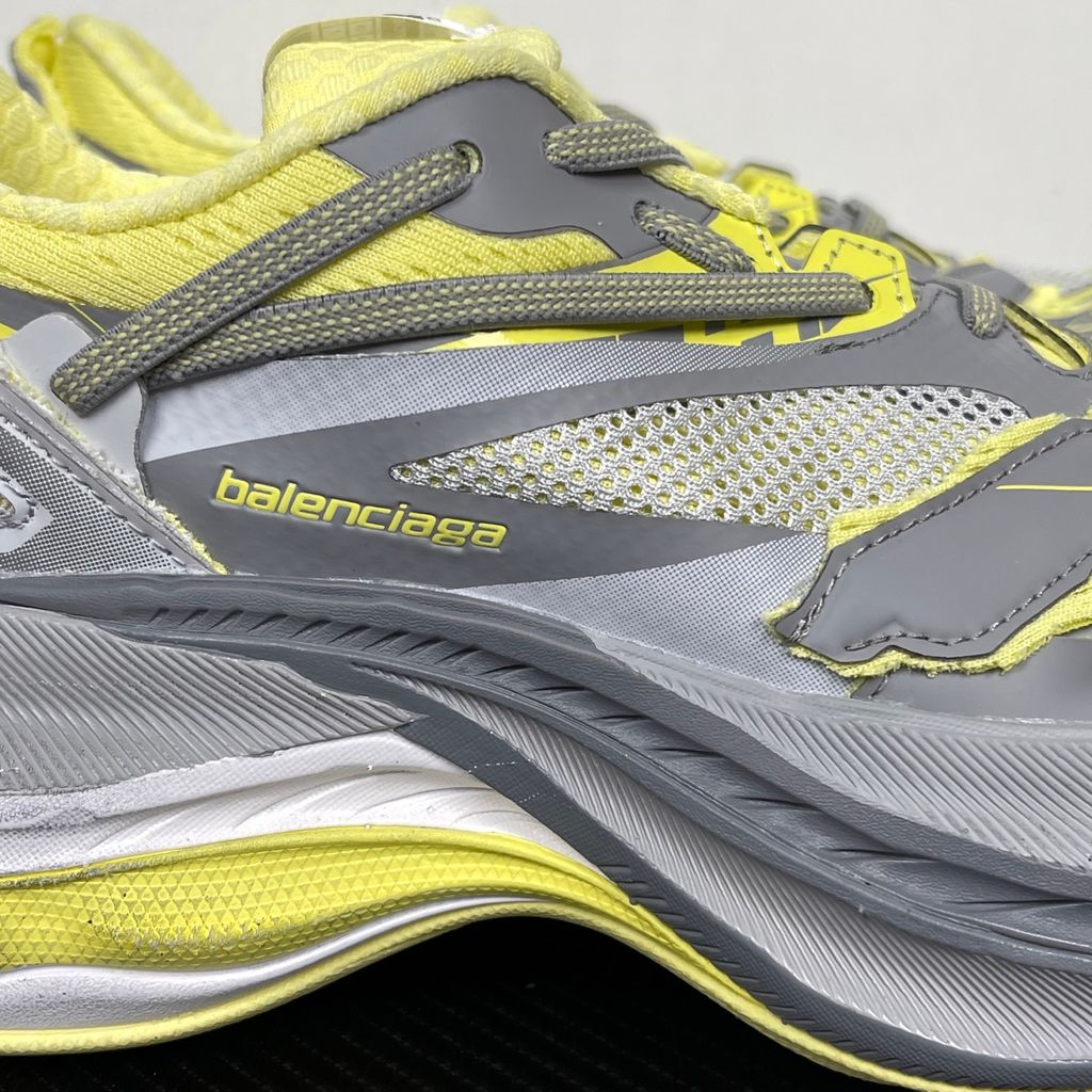 Side profile of the Balenciaga Jet sneaker, highlighting the dynamic grey and light yellow colorway, intricate embossed and printed detailing, and the dramatic 4.25cm thick sculpted sole unit.
