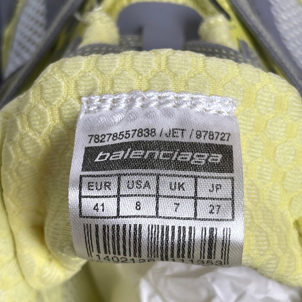 Side profile of the Balenciaga Jet sneaker, highlighting the dynamic grey and light yellow colorway, intricate embossed and printed detailing, and the dramatic 4.25cm thick sculpted sole unit.