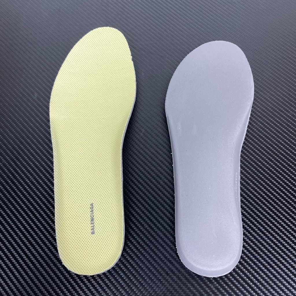 Side profile of the Balenciaga Jet sneaker, highlighting the dynamic grey and light yellow colorway, intricate embossed and printed detailing, and the dramatic 4.25cm thick sculpted sole unit.