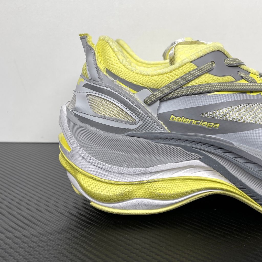 Side profile of the Balenciaga Jet sneaker, highlighting the dynamic grey and light yellow colorway, intricate embossed and printed detailing, and the dramatic 4.25cm thick sculpted sole unit.