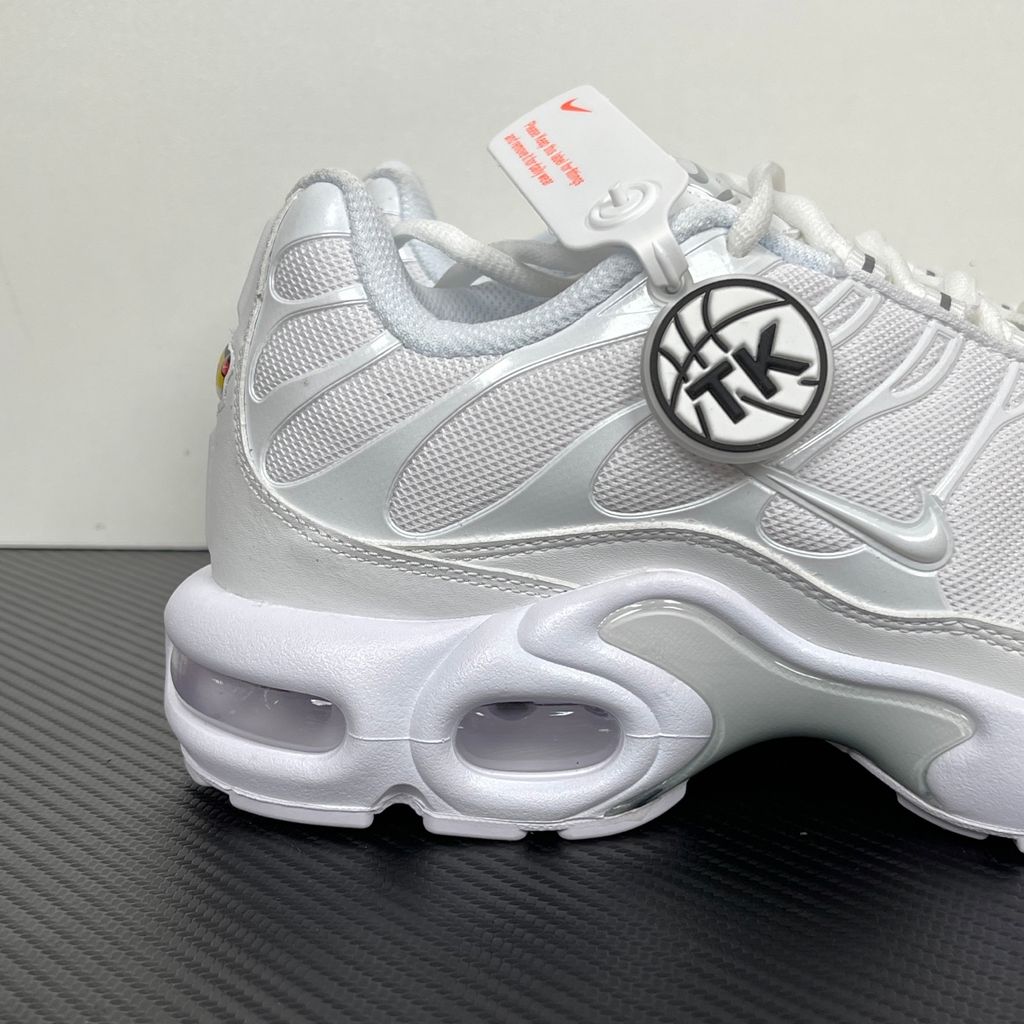 Side profile of the Nike Air Max Plus sneaker in the 'White Pure Platinum' colorway, highlighting the iconic wavy TPU overlays, clean breathable white mesh upper, and the visible Tuned Air cushioning units in the midsole.