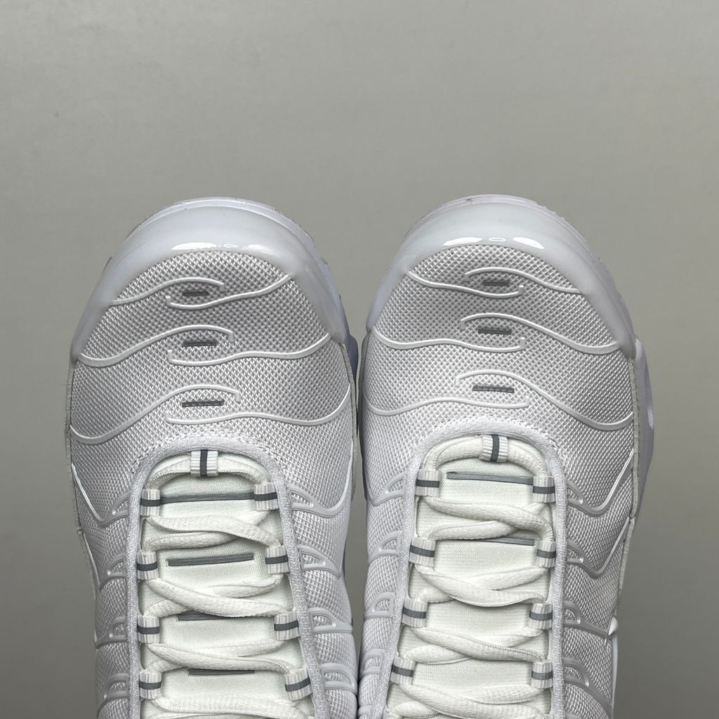 Side profile of the Nike Air Max Plus sneaker in the 'White Pure Platinum' colorway, highlighting the iconic wavy TPU overlays, clean breathable white mesh upper, and the visible Tuned Air cushioning units in the midsole.
