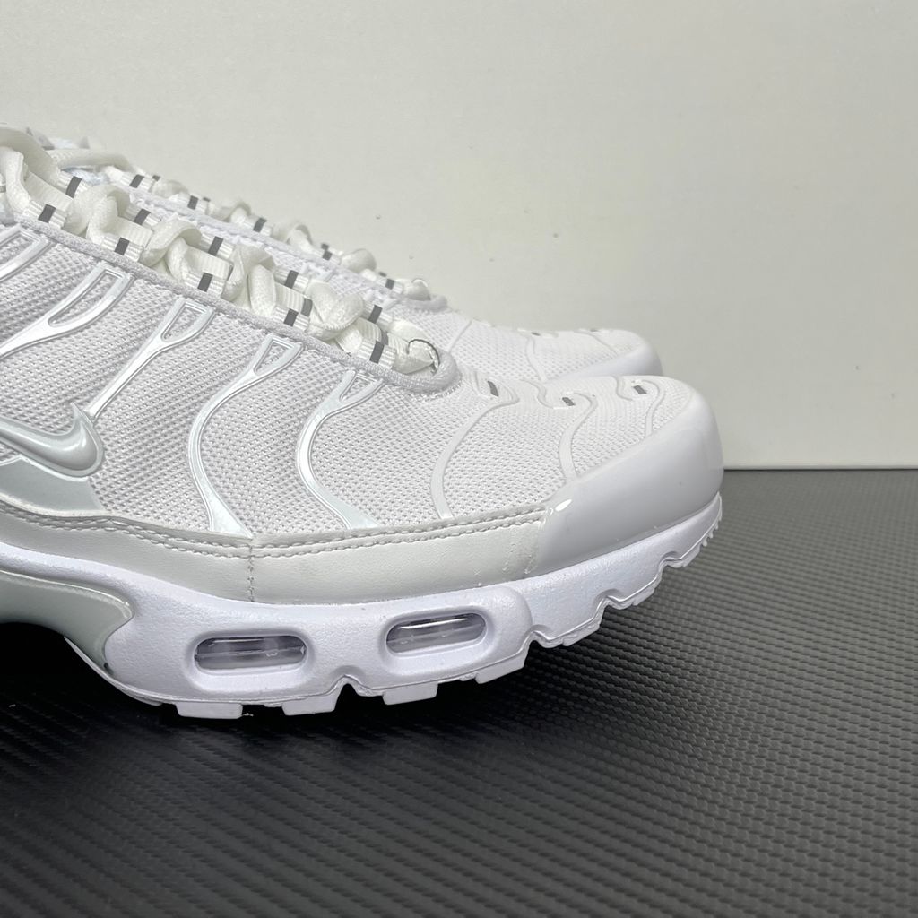Side profile of the Nike Air Max Plus sneaker in the 'White Pure Platinum' colorway, highlighting the iconic wavy TPU overlays, clean breathable white mesh upper, and the visible Tuned Air cushioning units in the midsole.