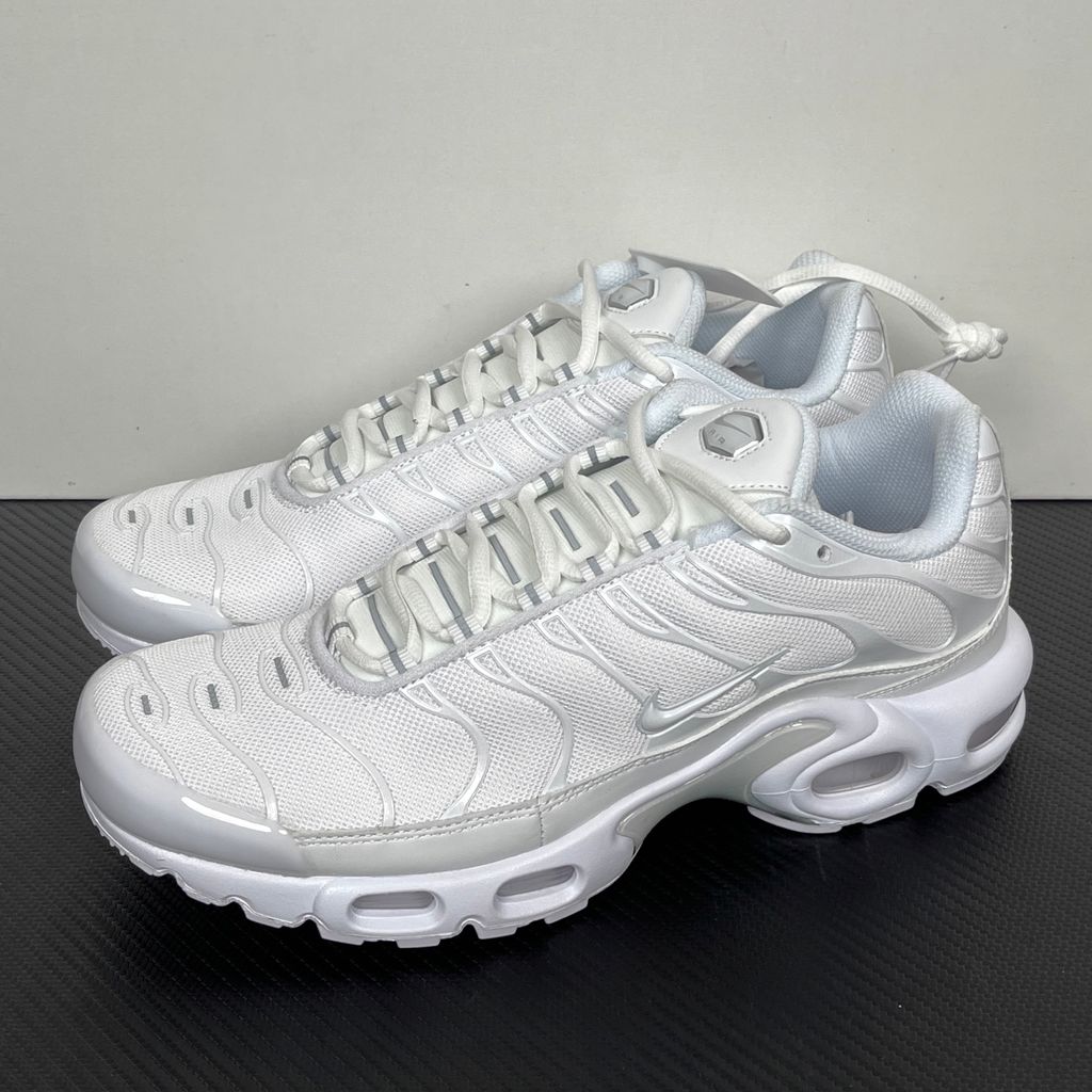 Side profile of the Nike Air Max Plus sneaker in the 'White Pure Platinum' colorway, highlighting the iconic wavy TPU overlays, clean breathable white mesh upper, and the visible Tuned Air cushioning units in the midsole.