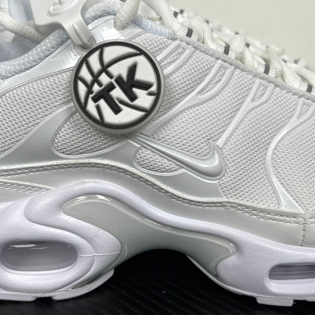 Side profile of the Nike Air Max Plus sneaker in the 'White Pure Platinum' colorway, highlighting the iconic wavy TPU overlays, clean breathable white mesh upper, and the visible Tuned Air cushioning units in the midsole.
