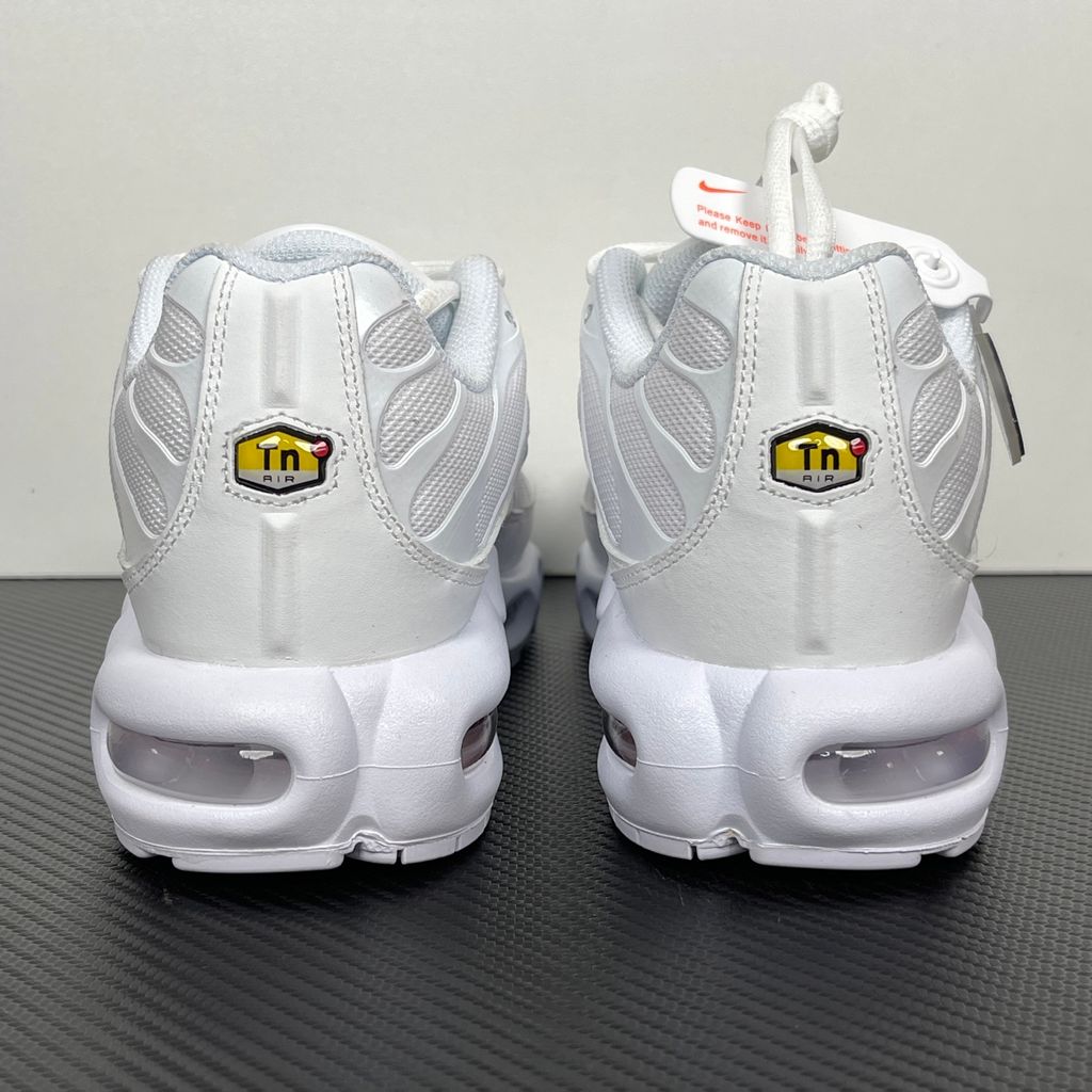 Side profile of the Nike Air Max Plus sneaker in the 'White Pure Platinum' colorway, highlighting the iconic wavy TPU overlays, clean breathable white mesh upper, and the visible Tuned Air cushioning units in the midsole.