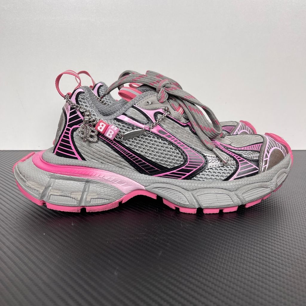 Side profile of the Balenciaga 3XL Gradient sneaker in 'Grey Pink', showcasing the exaggerated chunky midsole, intricate layered mesh and metallic upper, and the signature hanging chain charm hardware.