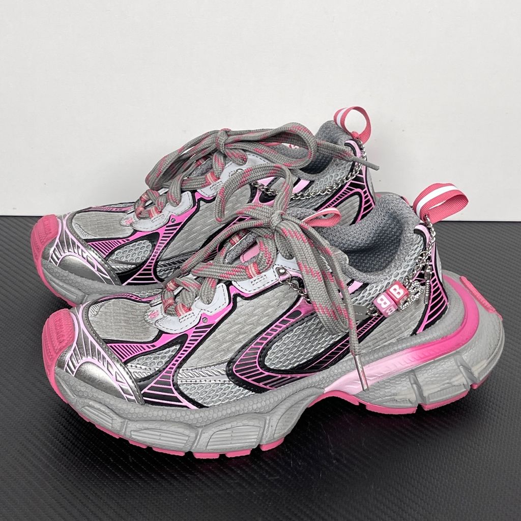 Side profile of the Balenciaga 3XL Gradient sneaker in 'Grey Pink', showcasing the exaggerated chunky midsole, intricate layered mesh and metallic upper, and the signature hanging chain charm hardware.
