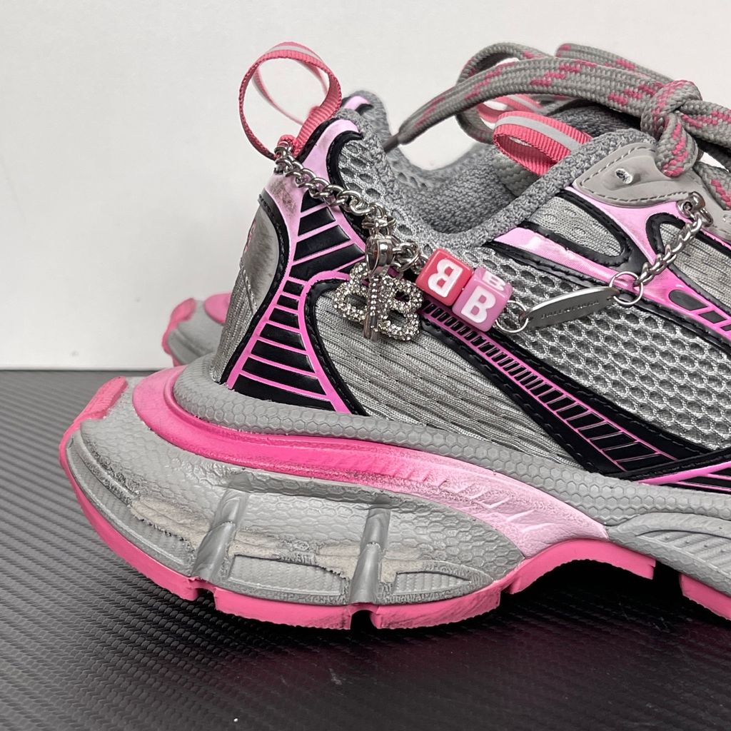 Side profile of the Balenciaga 3XL Gradient sneaker in 'Grey Pink', showcasing the exaggerated chunky midsole, intricate layered mesh and metallic upper, and the signature hanging chain charm hardware.