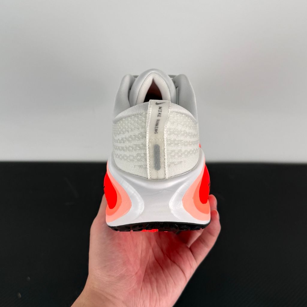 Side profile of the Nike Vomero Plus sneaker in the 'White Black Bright Crimson' colorway, showcasing the clean white mesh base, bold black synthetic overlays, and striking Bright Crimson accents on the midsole and branding.