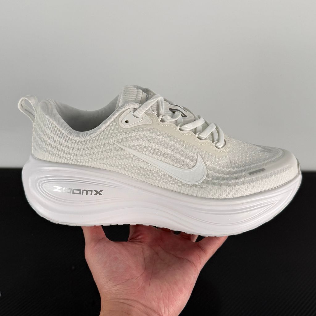 Side profile of the Nike Vomero Plus sneaker in the 'White' colorway, showcasing the clean, monochromatic mesh upper, tonal synthetic overlays, and the sculpted, high-performance foam midsole.