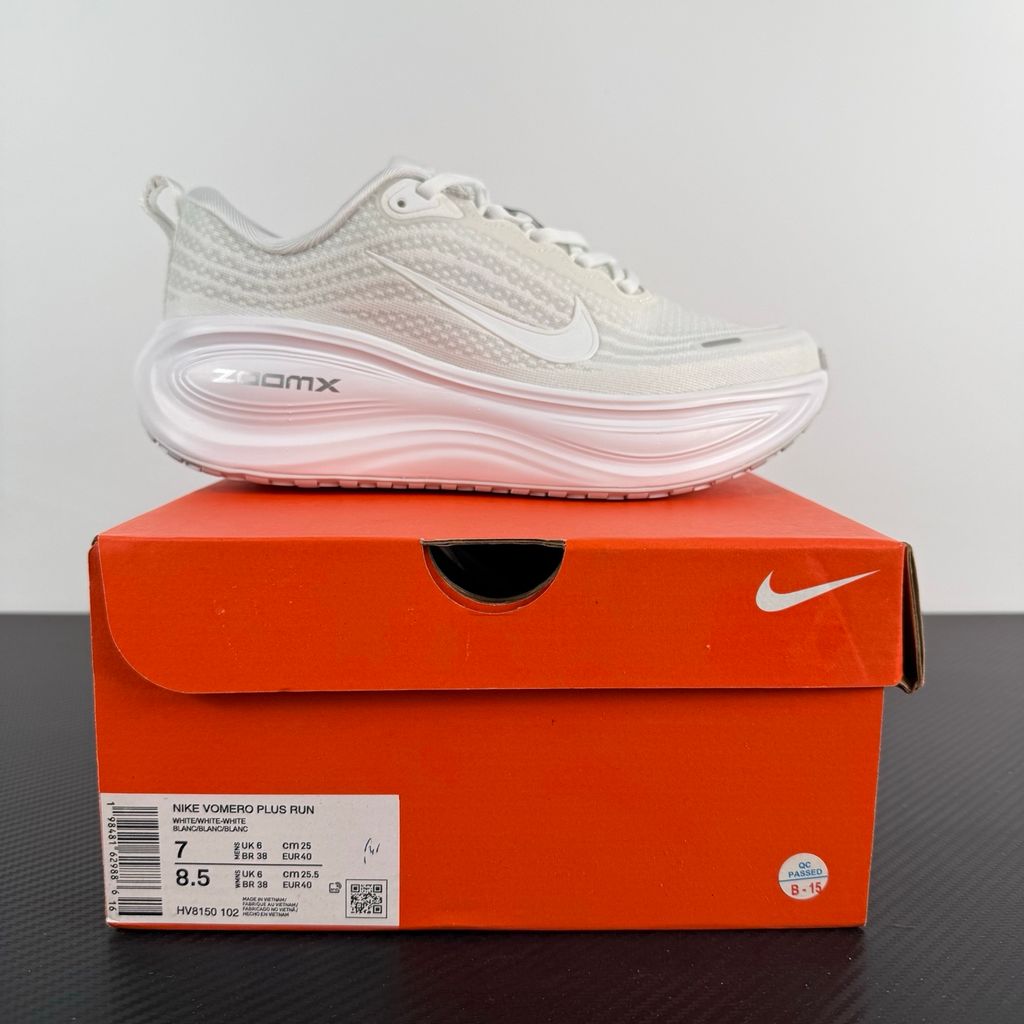 Side profile of the Nike Vomero Plus sneaker in the 'White' colorway, showcasing the clean, monochromatic mesh upper, tonal synthetic overlays, and the sculpted, high-performance foam midsole.