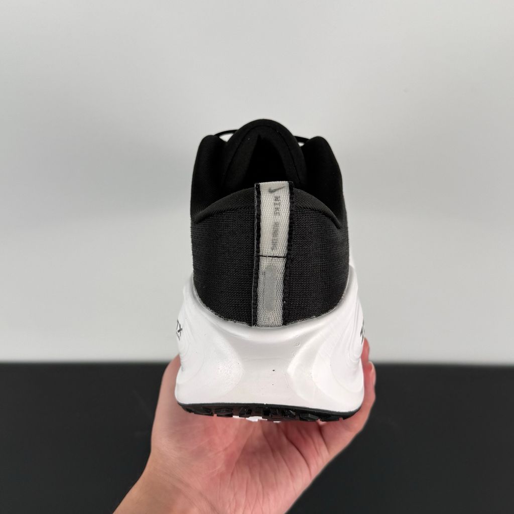 Side profile of the Nike Vomero Plus sneaker in the 'White' colorway, showcasing the clean, monochromatic mesh upper, tonal synthetic overlays, and the sculpted, high-performance foam midsole.