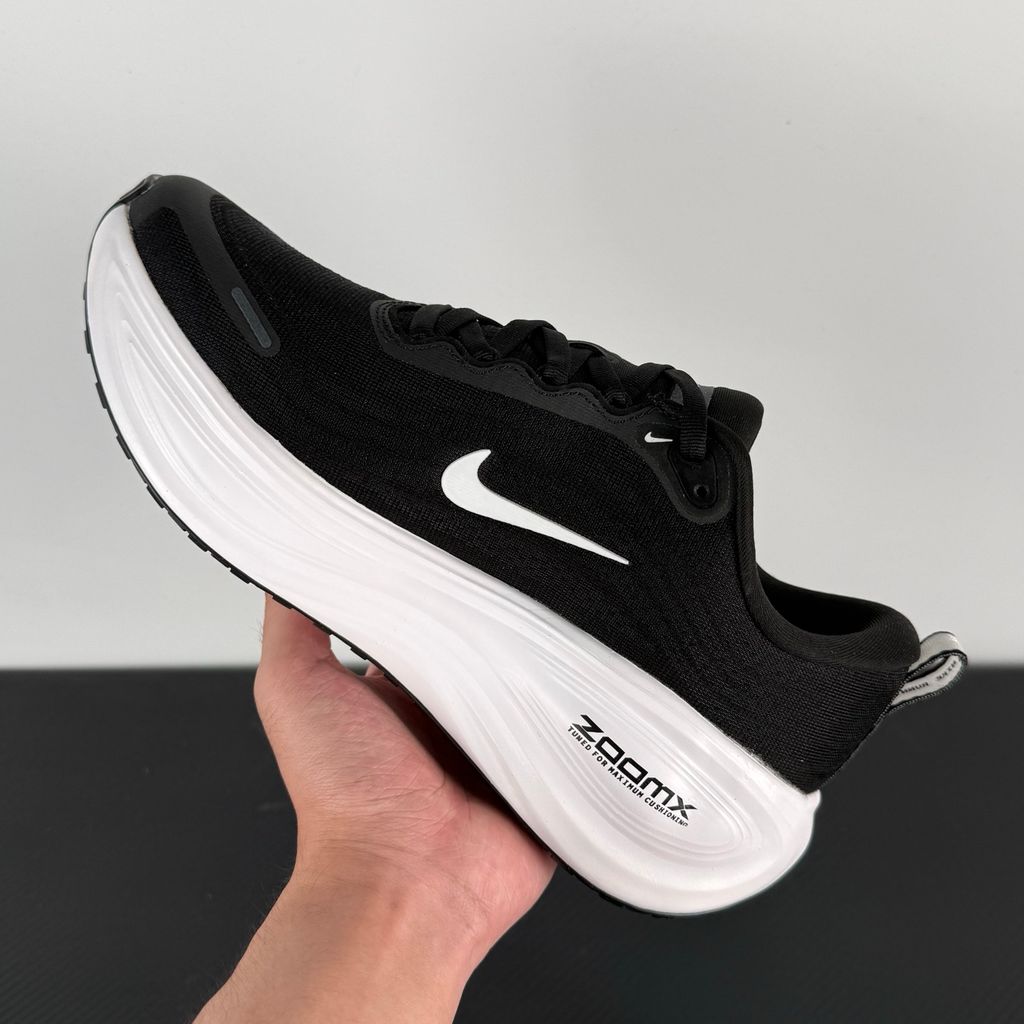 Side profile of the Nike Vomero Plus sneaker in the 'White' colorway, showcasing the clean, monochromatic mesh upper, tonal synthetic overlays, and the sculpted, high-performance foam midsole.