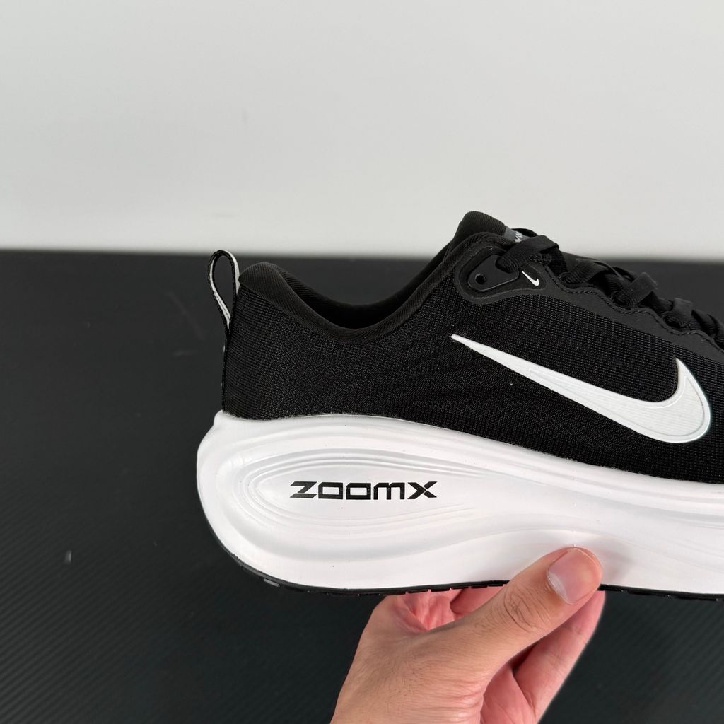 Side profile of the Nike Vomero Plus sneaker in the 'White' colorway, showcasing the clean, monochromatic mesh upper, tonal synthetic overlays, and the sculpted, high-performance foam midsole.