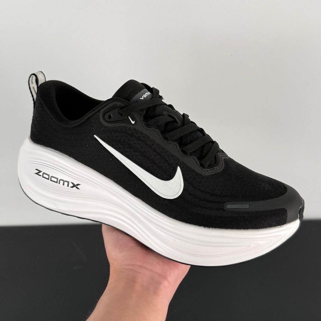 Side profile of the Nike Vomero Plus sneaker in the 'White' colorway, showcasing the clean, monochromatic mesh upper, tonal synthetic overlays, and the sculpted, high-performance foam midsole.