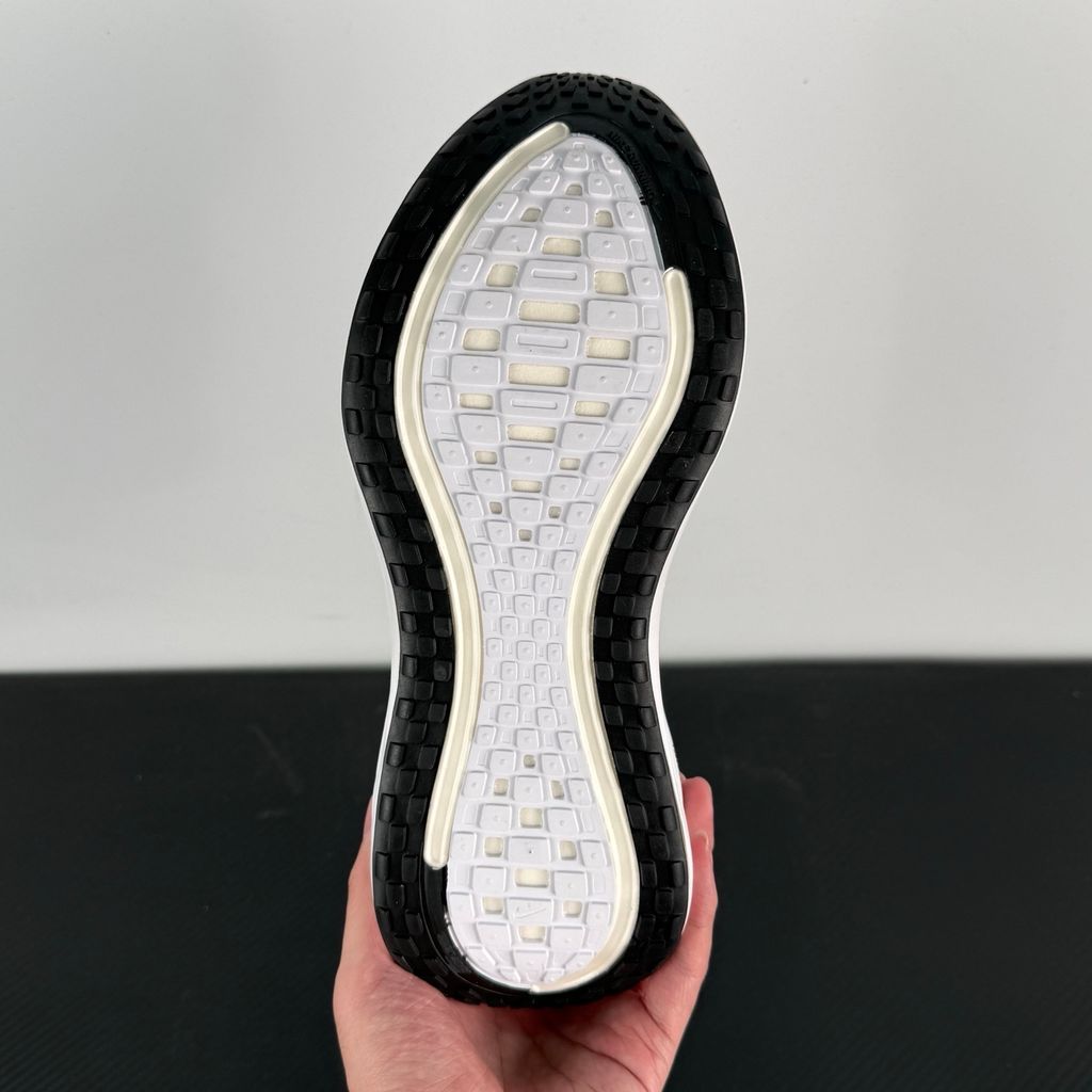 Side profile of the Nike Vomero Plus sneaker in the 'White' colorway, showcasing the clean, monochromatic mesh upper, tonal synthetic overlays, and the sculpted, high-performance foam midsole.