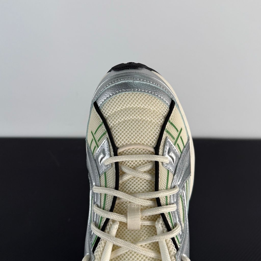 Side profile of the Under Armour SolaStone sneaker, highlighting the shimmering metallic silver upper, bold team kelly green branding and midsole accents, and the streamlined, athletic silhouette.