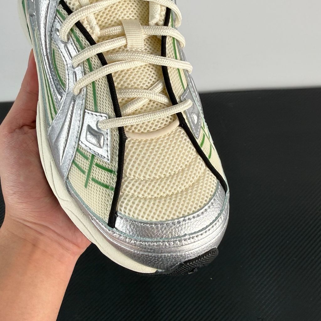 Side profile of the Under Armour SolaStone sneaker, highlighting the shimmering metallic silver upper, bold team kelly green branding and midsole accents, and the streamlined, athletic silhouette.
