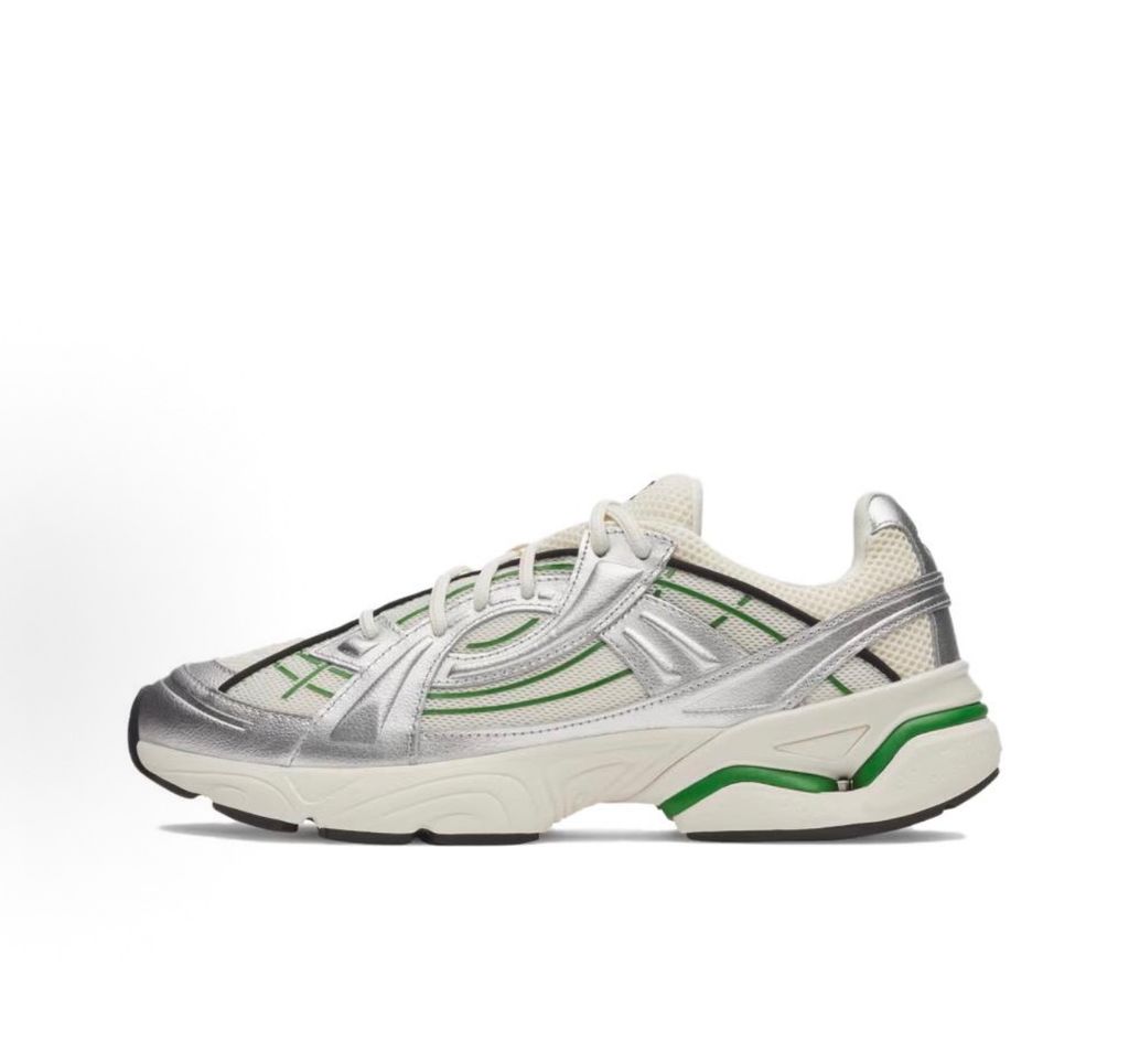 Side profile of the Under Armour SolaStone sneaker, highlighting the shimmering metallic silver upper, bold team kelly green branding and midsole accents, and the streamlined, athletic silhouette.