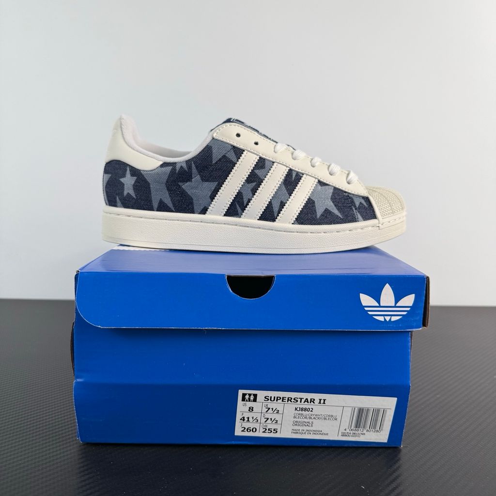 Side profile of the adidas Superstar II 'Denim Star' sneaker, showcasing the textured denim-style upper, classic serrated Three-Stripes branding, and the signature white rubber shell toe.