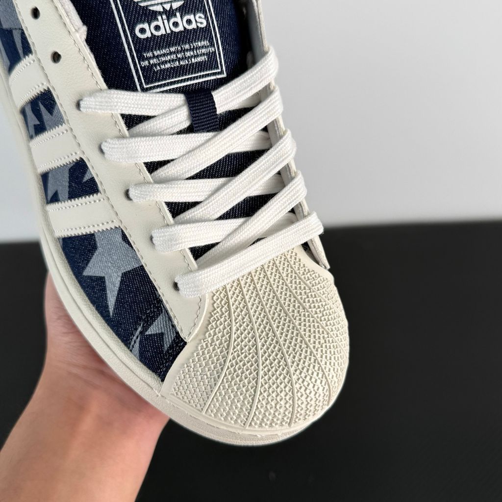 Side profile of the adidas Superstar II 'Denim Star' sneaker, showcasing the textured denim-style upper, classic serrated Three-Stripes branding, and the signature white rubber shell toe.