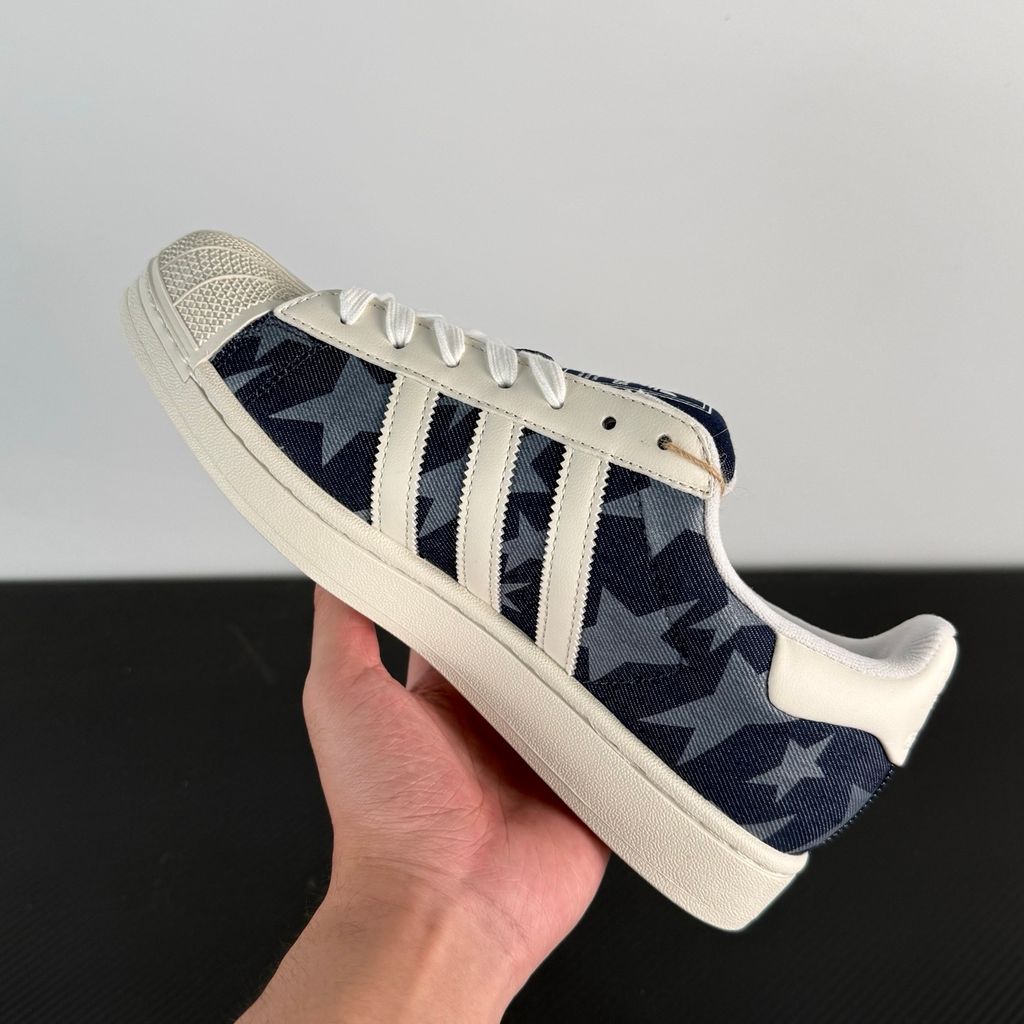 Side profile of the adidas Superstar II 'Denim Star' sneaker, showcasing the textured denim-style upper, classic serrated Three-Stripes branding, and the signature white rubber shell toe.