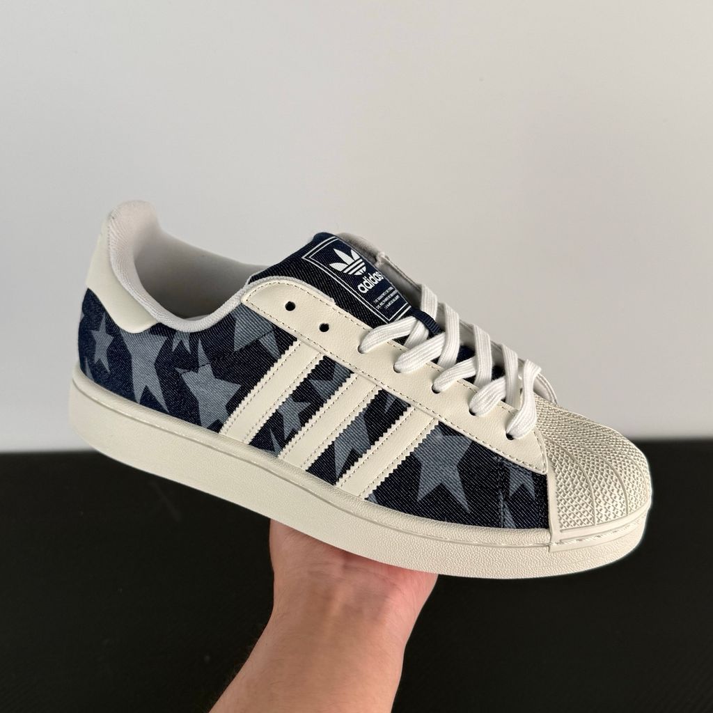 Side profile of the adidas Superstar II 'Denim Star' sneaker, showcasing the textured denim-style upper, classic serrated Three-Stripes branding, and the signature white rubber shell toe.