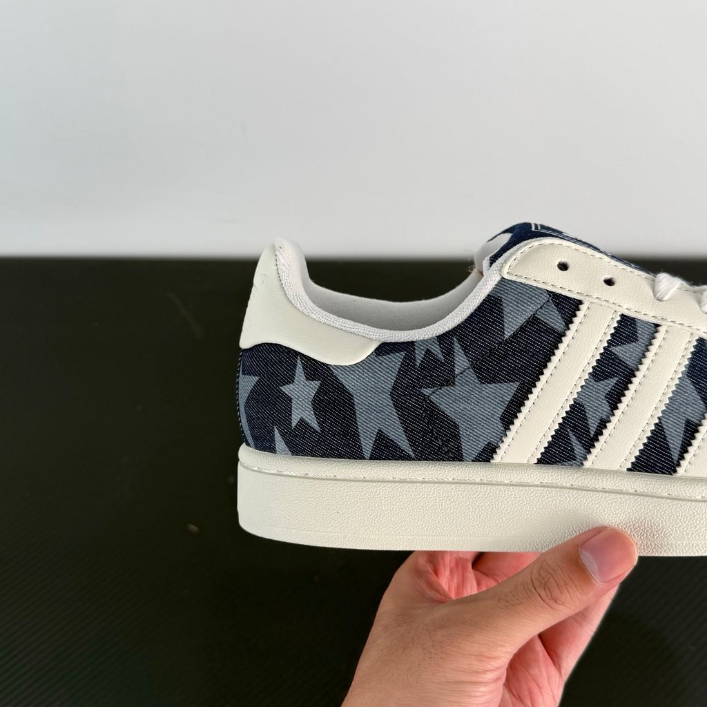 Side profile of the adidas Superstar II 'Denim Star' sneaker, showcasing the textured denim-style upper, classic serrated Three-Stripes branding, and the signature white rubber shell toe.
